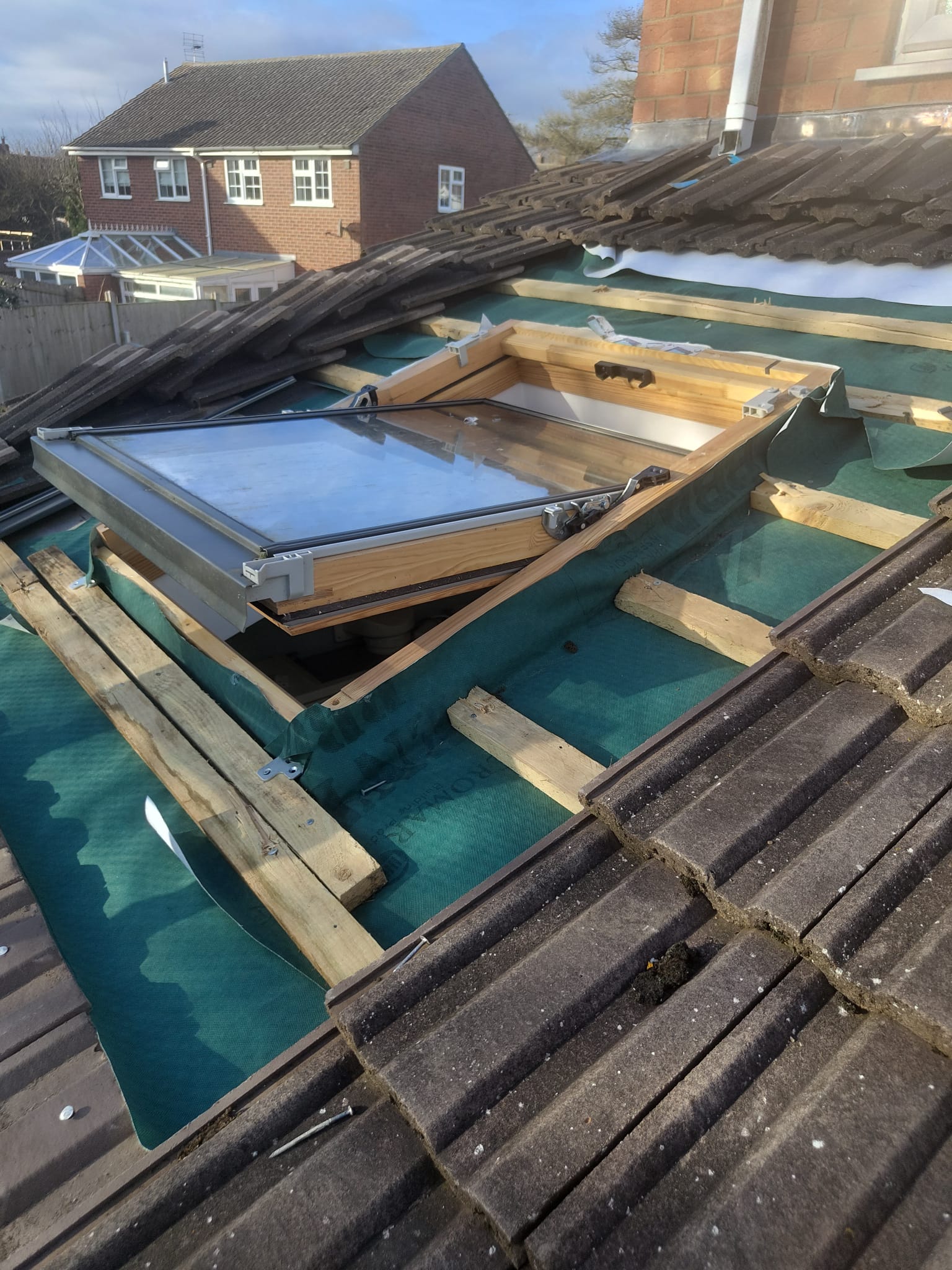 A new roof window being fitted, with fresh battens and membrane around it